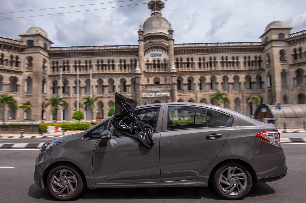 A convoy of cars with black flags are seen around Kuala Lumpur City Centre during a protest July 24, 2021. — Picture by Shafwan Zaidon