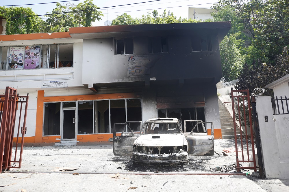 A car is seen outside a house, both set on fire by locals after a firefight between police and the suspected assassins of President Jovenel Moise who was shot dead early Wednesday at his home, in Port-au-Prince, Haiti July 8, 2021. ― Reuters pic