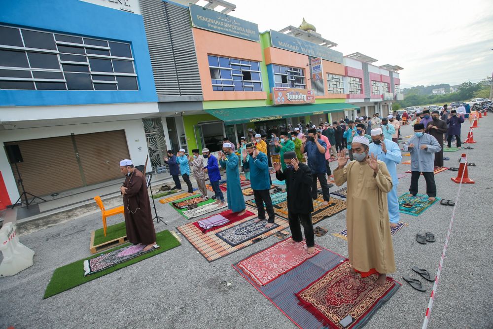 Residents of Taman Meru Perdana 2 perform Aidiladha prayers in front of a row of shoplots in Ipoh July 20, 2021. u00e2u20acu201d Picture by Farhan Najib
