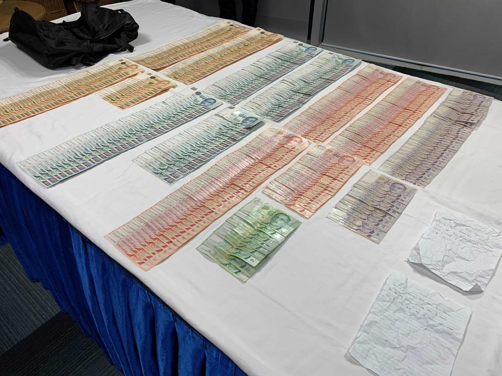 Cash, two handwritten notes and a bag that were seized by the police in relation to a robbery at Bukit Batok Street 31 on July 8, 2021. u00e2u20acu2022 TODAY pic