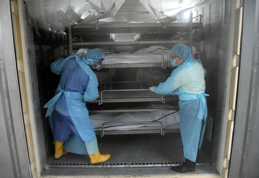 Hospital Sultanah Aminah staff are pictured in a container which doubles as a morgue as they handle remains of deceased Covid-19 patients in Johor Baru July 21, 2021. — Bernama pic