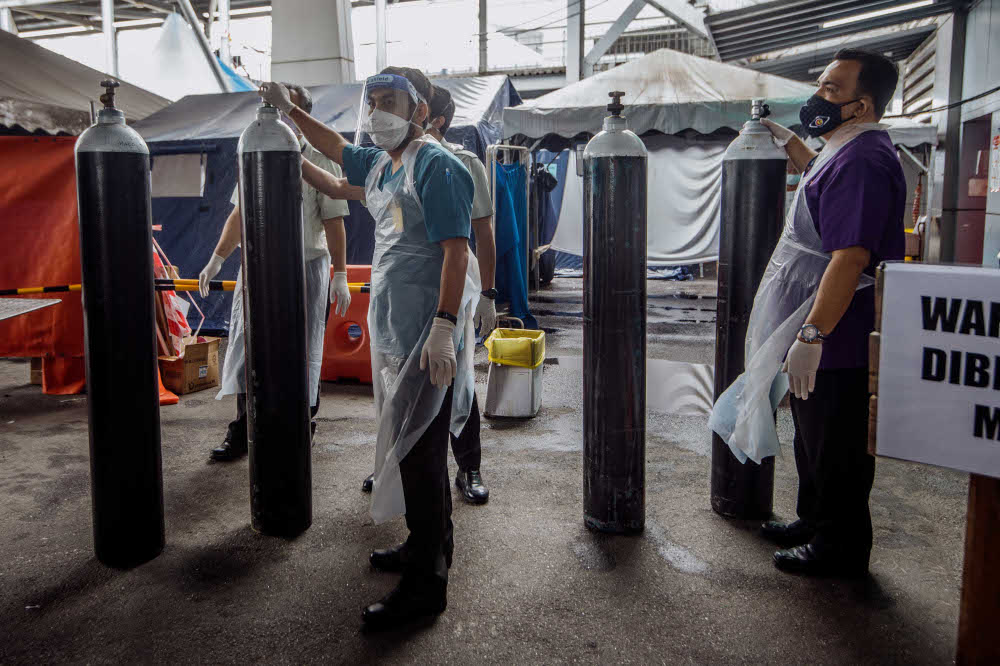 Workers arrange medical oxygen cylinders to be sent to the Covid-19 Low-Risk Quarantine and Treatment Centre (PKRC) at the Malaysia Agriculture Expo Park (MAEPS) at Hospital Serdang July 26, 2021. u00e2u20acu201d Picture by Shafwan Zaidon