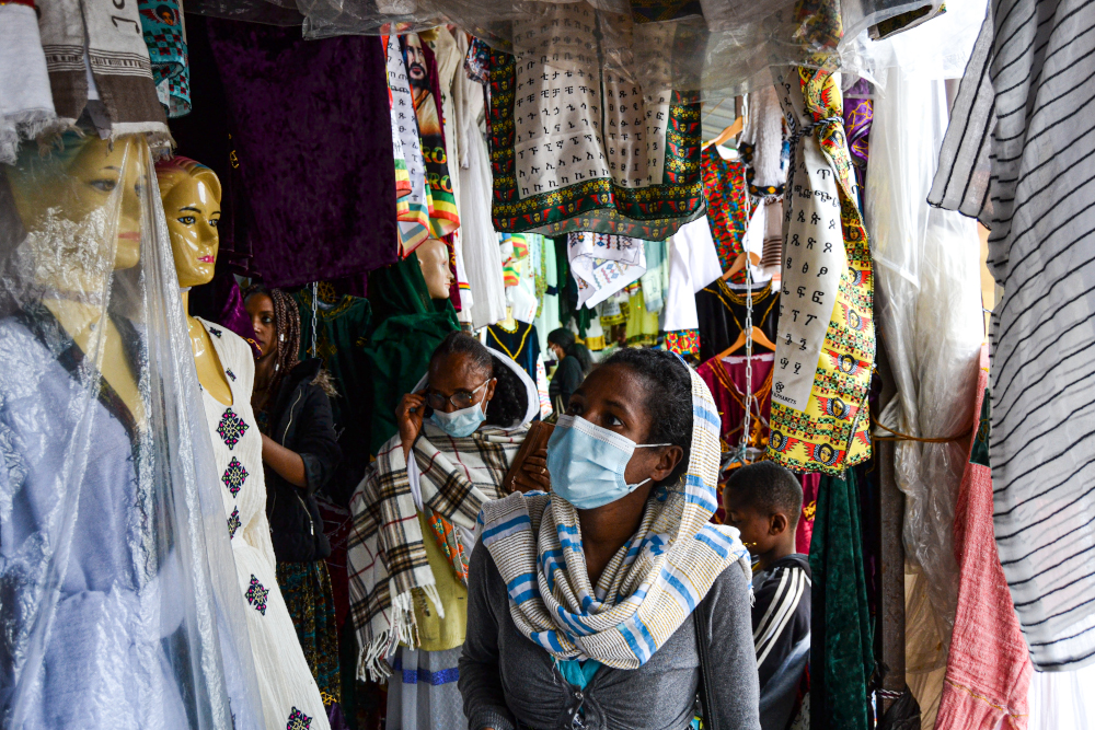Women look at traditional clothes displayed in the stores of Shiromeda market in Addis Ababa July 23, 2021. — Thomson Reuters Foundation pic