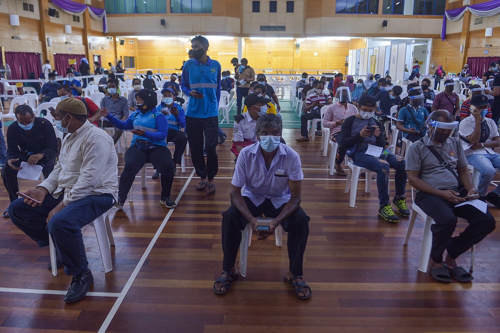 Foreign workers wait to receive their Covid -19 jabs at Komplek Sukan PKNS in Kelana Jaya August 10, 2021. u00e2u20acu201d Picture by Miera Zulyana
