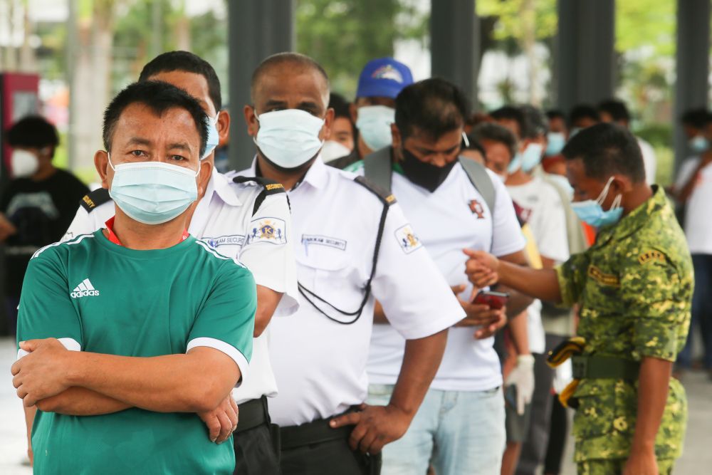 Foreign workers queue as they wait to get their Covid-19 jab at the Bukit Jalil Stadium vaccination centre August 10, 2021. ― Picture by Choo Choy May