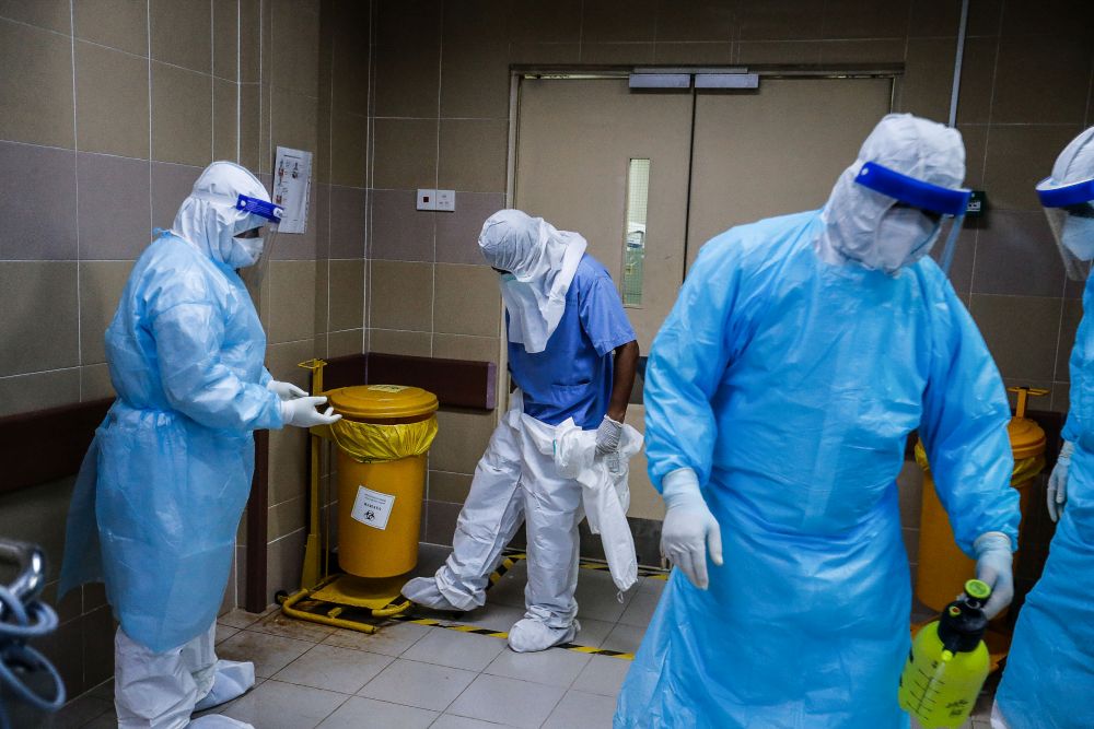 Forensics personnel don full personal protective gear as they prepare the body of a recently deceased Covid-19 patient for burial at the Penang General Hospital, August 24, 2021. — Picture by Sayuti Zainudin