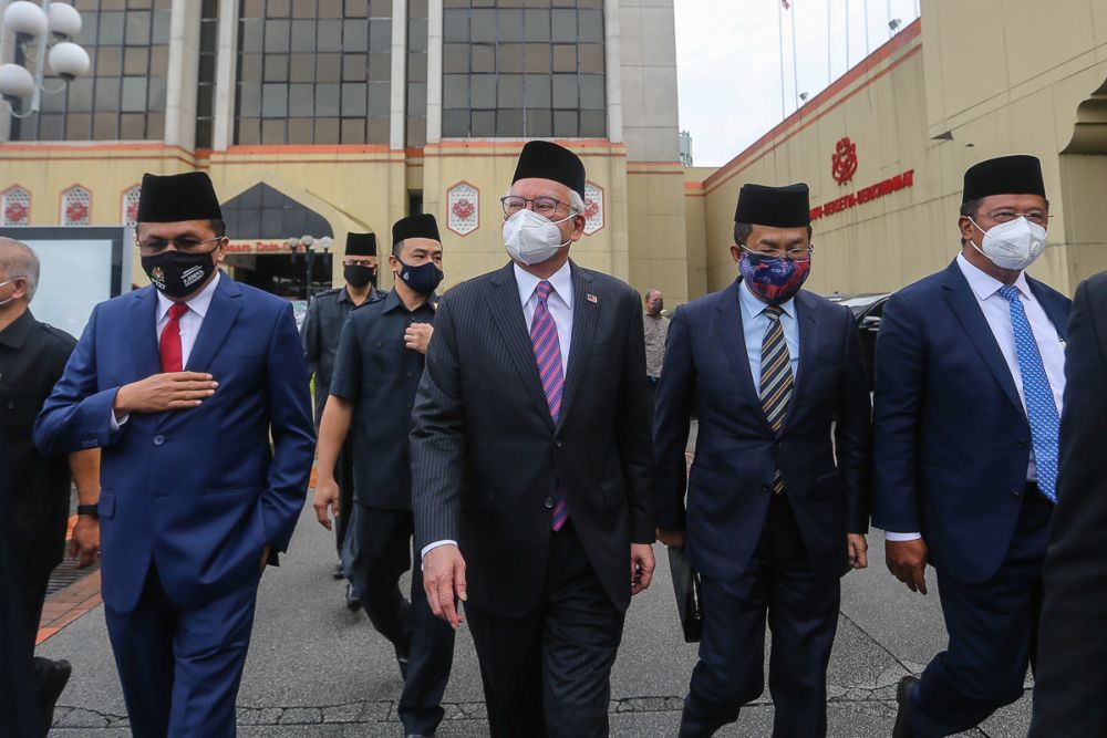 Datuk Seri Najib Razak (centre) and other Umno MPs are pictured boarding a bus ahead of their audience with the Yang di-Pertuan Agong at Istana Negara in Kuala Lumpur August 19, 2021. u00e2u20acu201d Picture by Yusof Mat Isa