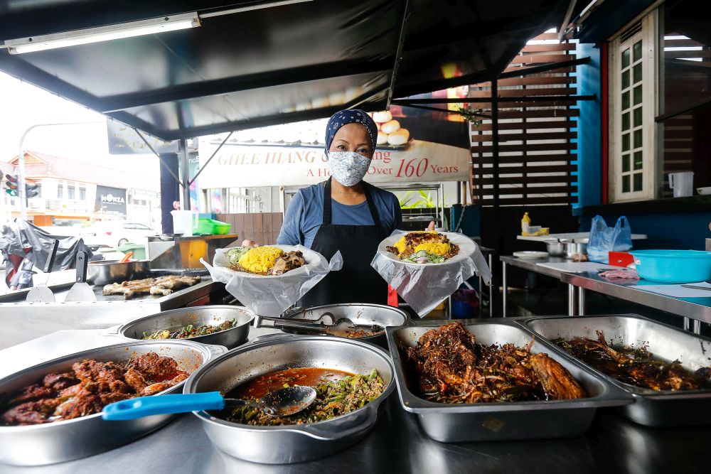 Ayu Yusoff strikes a pose with her signature dish — Nasi Ranchak Ayam — at Quallys Nusantara Kitchen on Jalan Burmah, George Town on September 21, 2021. — Pictures by Sayuti Zainudin