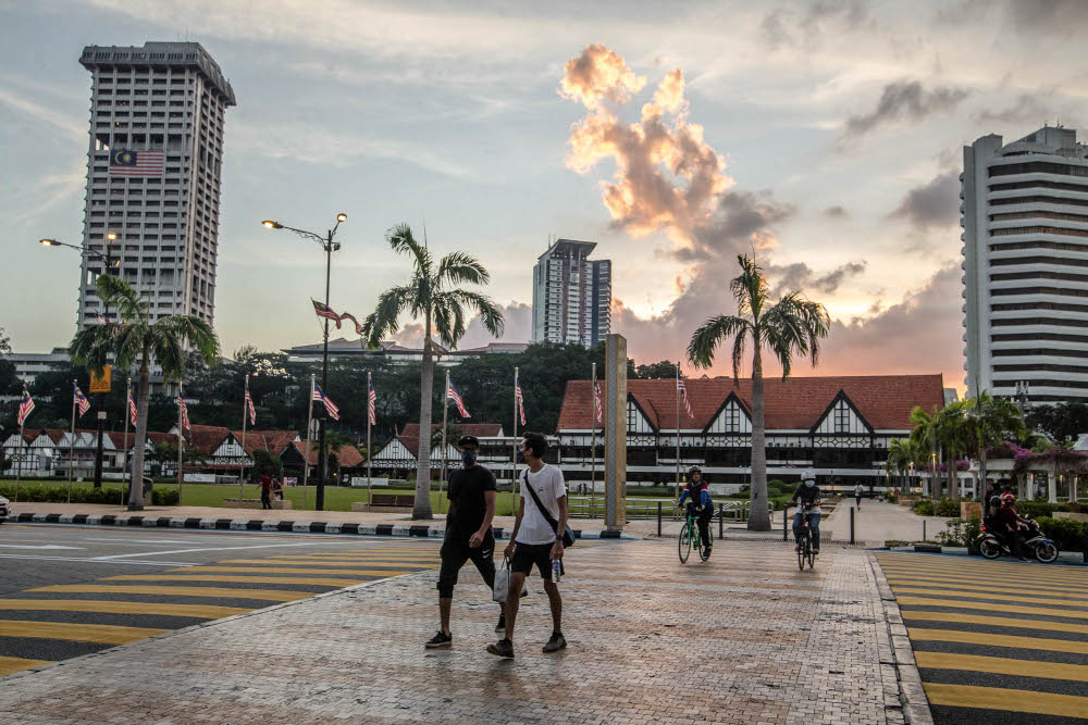 2021 年 9 月 21 日，戴着口罩的人们走在吉隆坡的街道上。 — 图片作者 Firdaus Latif