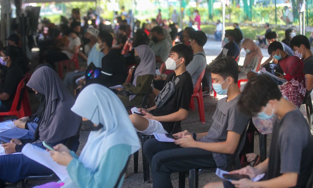 Students wait to receive their Covid-19 jab at the Kinta Town Hall in Batu Gajah September 21, 2021. u00e2u20acu201d Picture by Farhan Najib