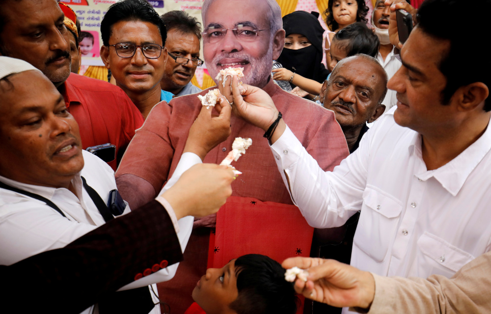 People offer pieces of a cake to a cut-out of India’s Prime Minister Narendra Modi as they celebrate his 71st birthday at an event in Ahmedabad September 17, 2021. — Reuters pic