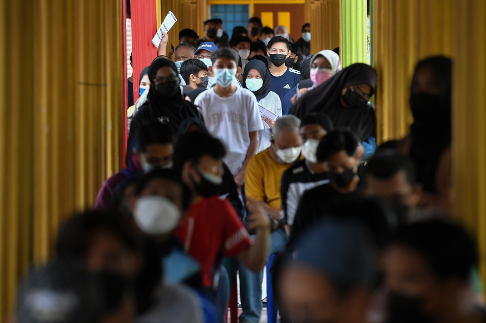 Students accompanied by their parents wait for their turn to be vaccinated at Sekolah Menengah Sultan Sulaiman in Kuala Terengganu, September 21, 2021. — Bernama pic 