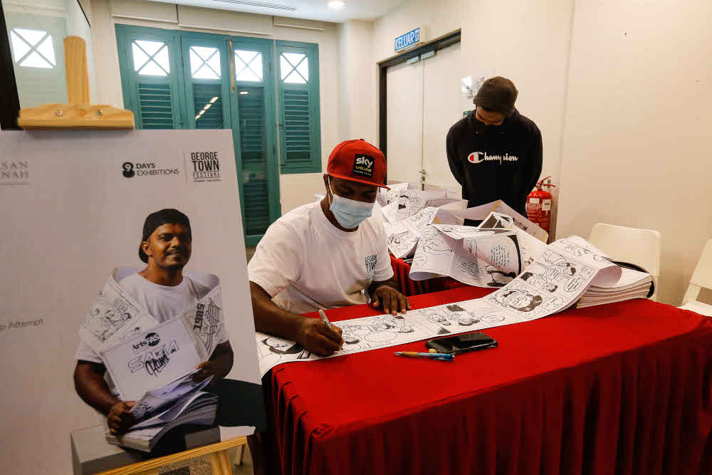 Local cartoonist Azmi Hussin is seen in his attempt to draw the longest comic strip in the country during the 3 X 3 Group Exhibition in conjunction with the Georgetown Festival in Penang November 26, 2021. — Picture by Sayuti Zainudin