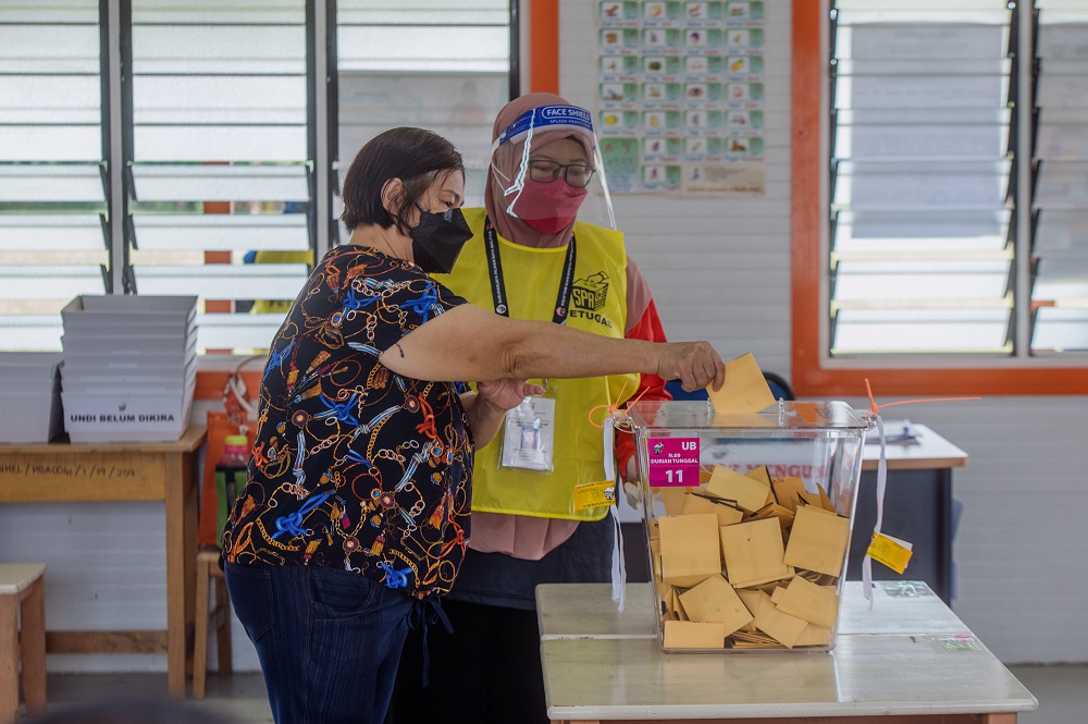 A voter casts her vote in Durian Tunggal during the Melaka state election on November 20, 2021. ― Pictures by Shafwan Zaidon