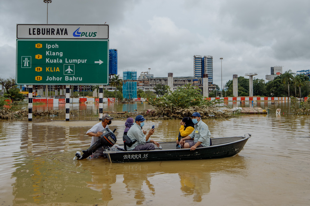 A man uses a boat to rescue people after persistent rainfall caused massive floods in Shah Alam, December 19, 2021. u00e2u20acu2022 Picture by Shafwan Zaidon
