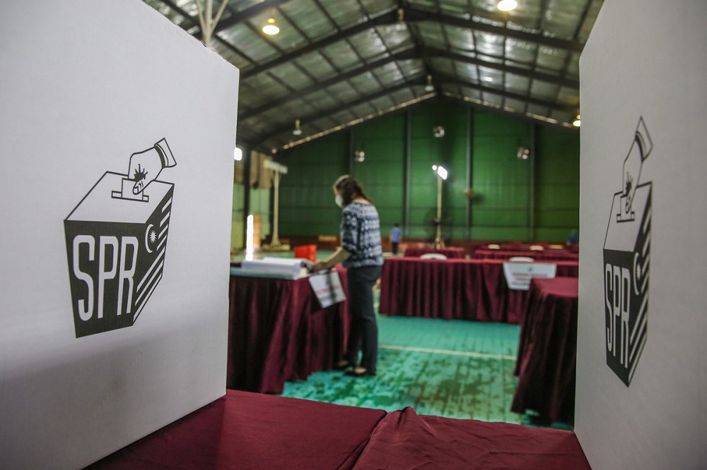 Election Commission officials get the polling station at Dewan Badminton Kompleks Perumahan Polis Tabuan Jaya ready ahead of early voting in Kuching December 13, 2021. — Picture by Yusof Mat Isa