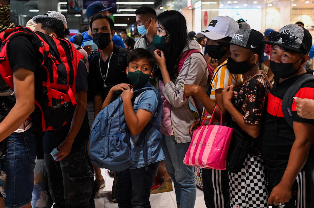 Des personnes portant des masques faciaux attendent de prendre un bus pour se rendre dans les provinces, un jour avant le réveillon du Nouvel An, dans un terminal de bus à Paranaque City, Metro Manila, Philippines, le 30 décembre 2021. — Photo Reuters