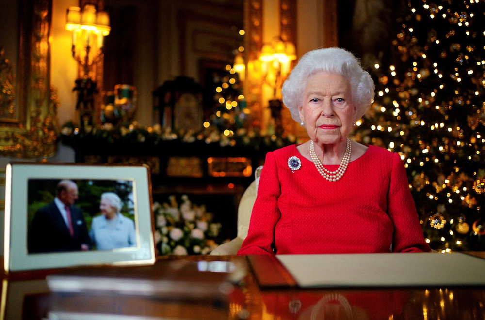 Britain's Queen Elizabeth records her annual Christmas broadcast in the White Drawing Room in Windsor Castle, next to a photograph of the queen and the Duke of Edinburgh, in Windsor, Britain, December 23, 2021. u00e2u20acu201d Reuters picnnn