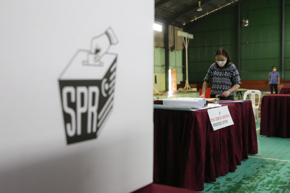 Election Commission officials get the polling station at Dewan Badminton Kompleks Perumahan Polis Tabuan Jaya ready ahead of early voting in Kuching December 13, 2021.