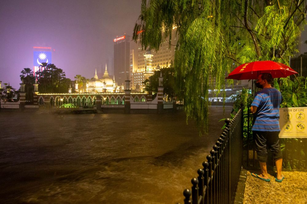 A man looks on as floodwaters rise in Kuala Lumpur amid incessant rain December 18, 2021.  u00e2u20acu2022 Picture by Firdaus Larif