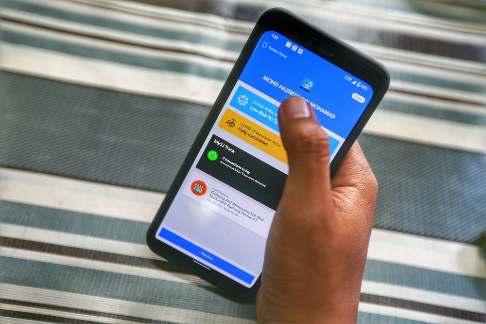 A man uses the MySejahtera trace feature. ― Picture by Ahmad Zamzahuri