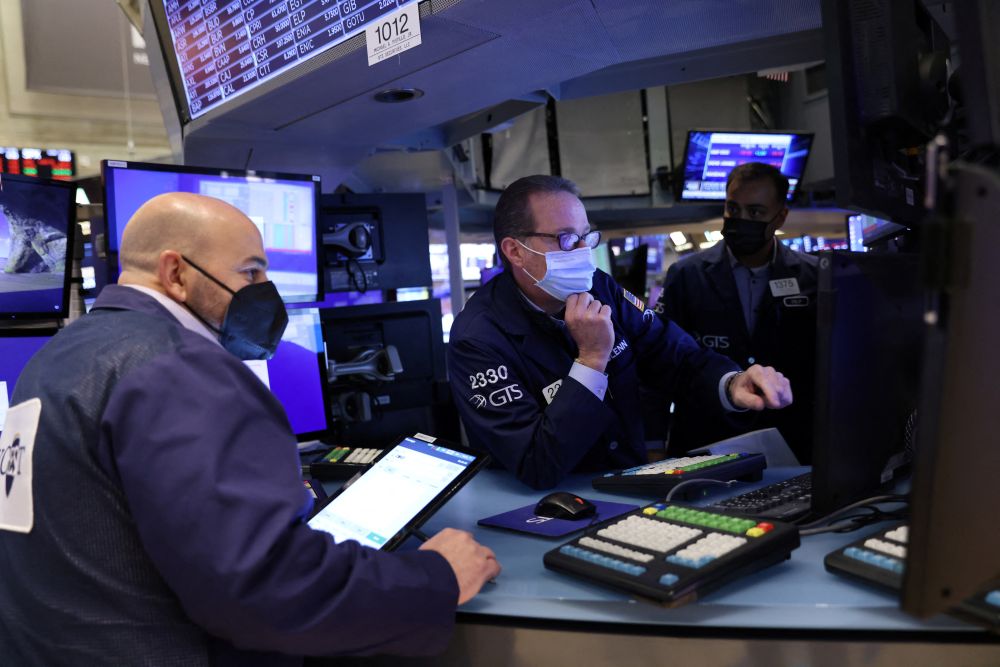 Traders in a face masks work on the trading floor at the New York Stock Exchange as the Omicron coronavirus variant continues to spread in Manhattan December 20, 2021. —Reuters pic