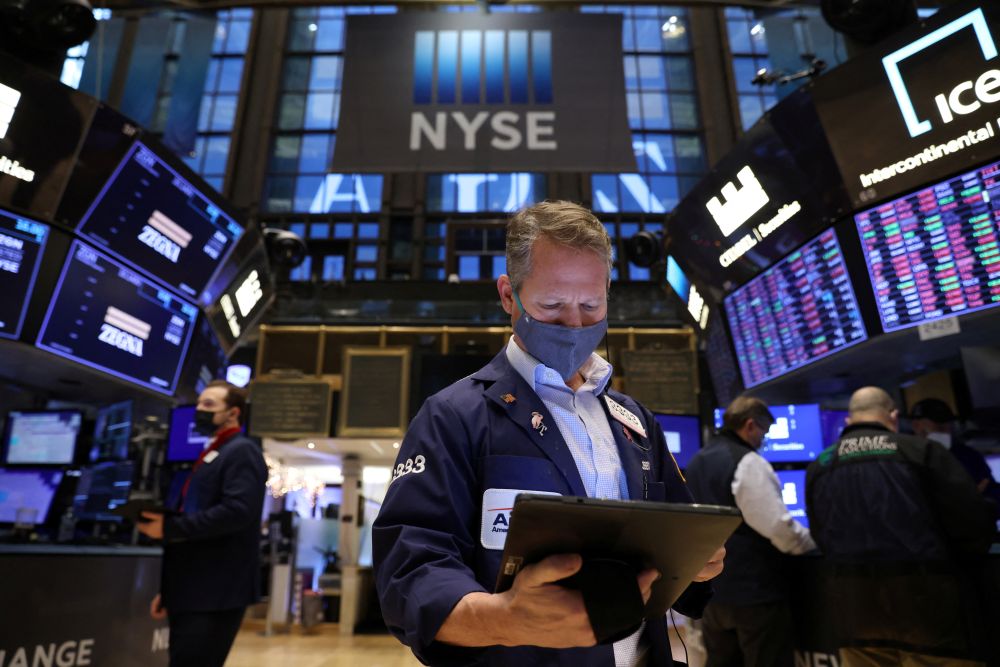 A trader in a face mask works on the trading floor at the New York Stock Exchange as the Omicron coronavirus variant continues to spread in Manhattan December 20, 2021. —Reuters pic