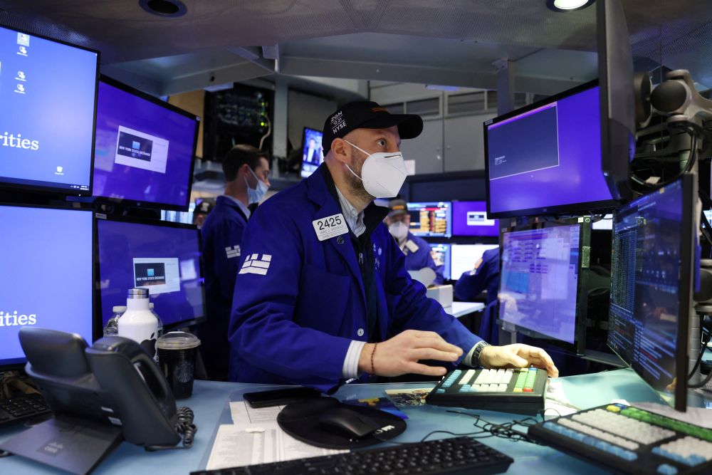 A trader in a face mask works on the trading floor at the New York Stock Exchange as the Omicron coronavirus variant continues to spread in Manhattan December 20, 2021. —Reuters pic