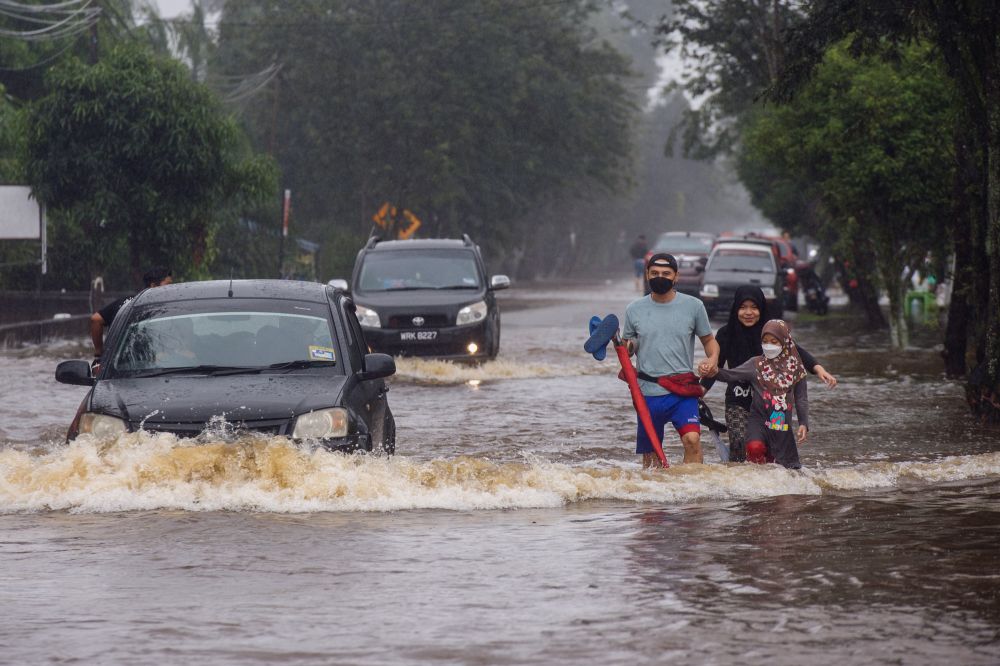 Motorists attempt to drive through floodwaters in Kampung Jalan Kebung in Shah Alam December 18, 2021. u00e2u20acu2022 Picture by Shafwan Zaidon