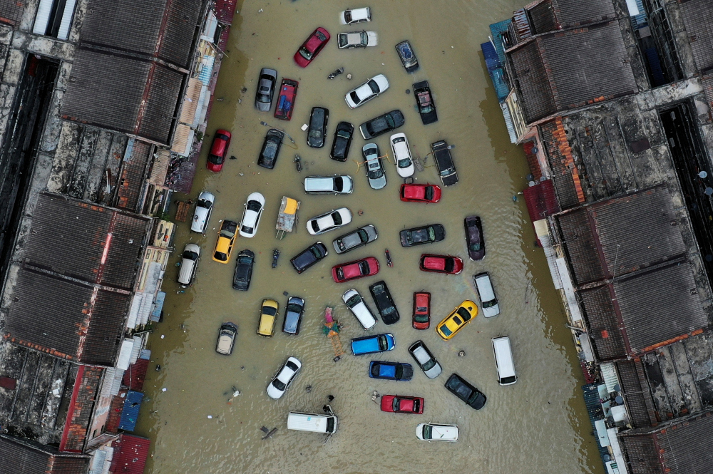 Kendaraan dan bangunan terendam banjir di Taman Sri Muda Shah Alam, di Selangor, 21 Desember 2021. — Reuters pic