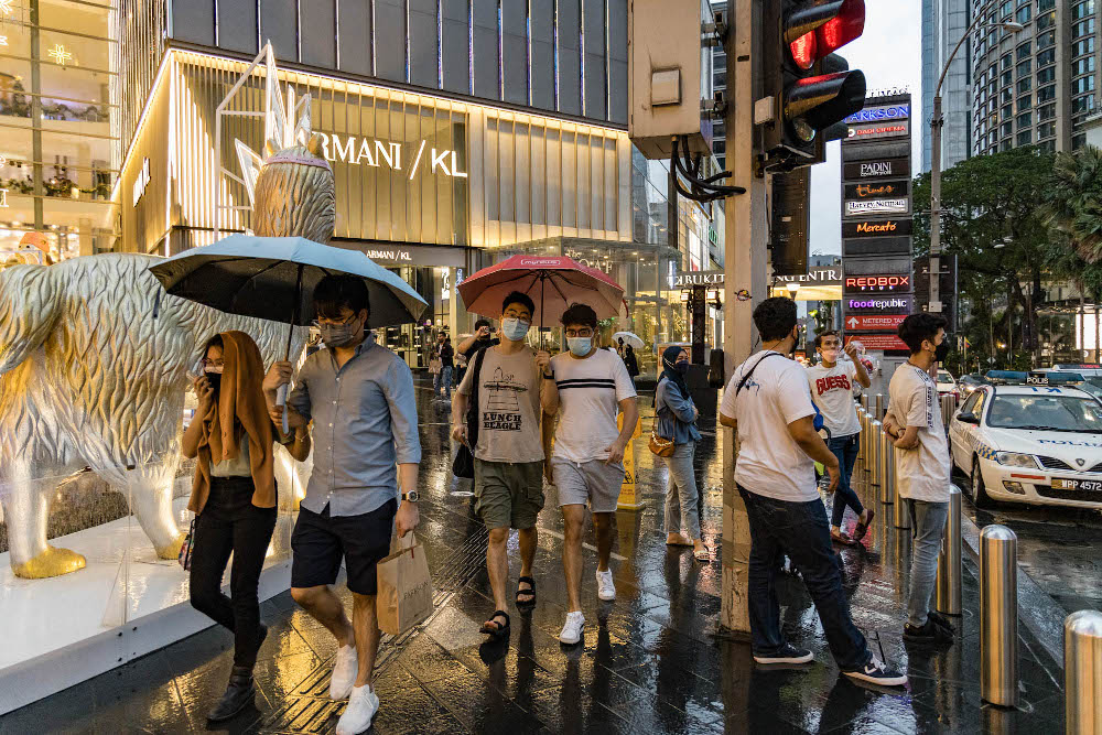 People hold umbrellas while walking on a street during a rainy day in Kuala Lumpur January 2, 2022. u00e2u20acu201d Picture by Firdaus Latif