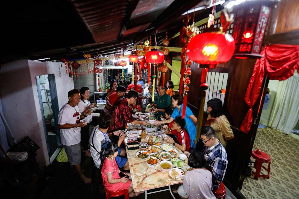 A family having their reunion dinner at Lim Jetty, Weld Quay on January 31, 2022. — Picture by Sayuti Zainudin