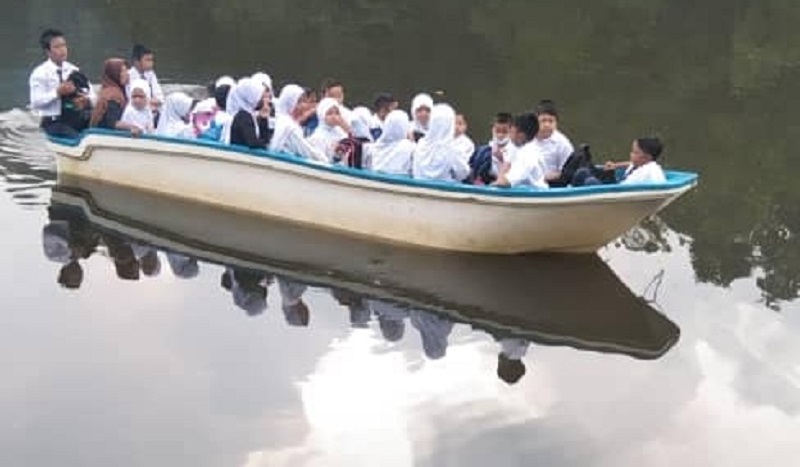Para siswa dalam perjalanan menuju sekolah di SK Mangkapon, Pitas ini tidak memiliki pengaman dasar saat menaiki perahu rompi pengaman.  Gambar melalui Facebook/A Korn Korn
