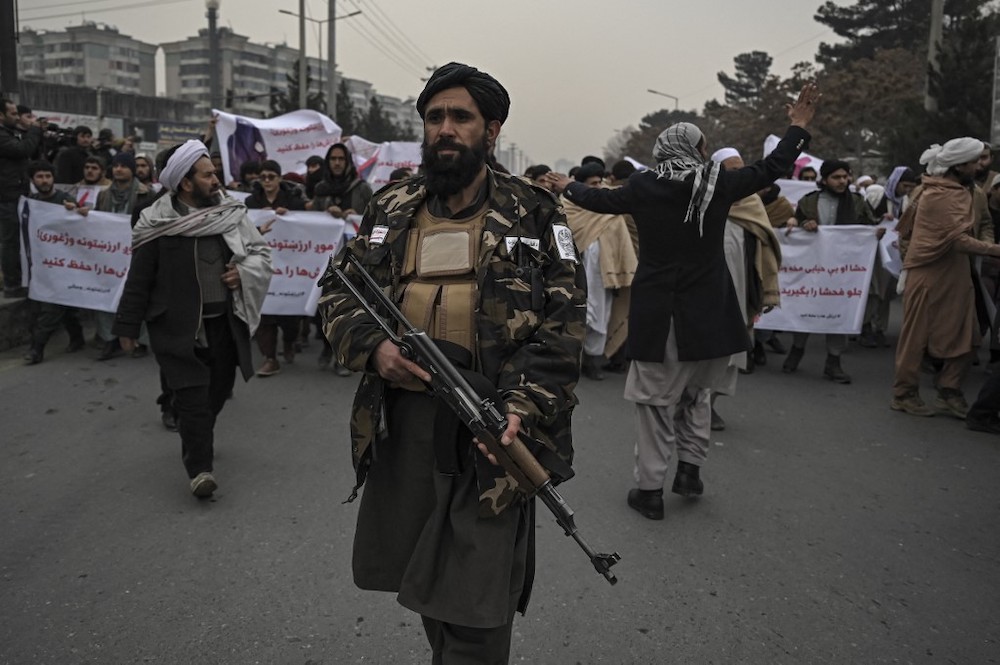 Taliban fighters patrol along a street during a demonstration by people to condemn the recent protest by the Afghan women's rights activists, in Kabul on January 21, 2022. u00e2u20acu2022 AFP picnn