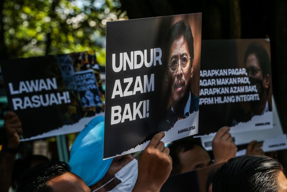 PKR members hold up placards protesting alleged corruption in MACC outside the Dang Wangi district police headquarters in Kuala Lumpur January 7, 2022. — Picture by Hari Anggara