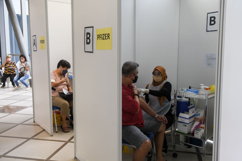 People receive their Covid-19 booster shot at the KL Gateway Mall in Kuala Lumpur January 5, 2022. — Picture by Ahmad Zamzahuri