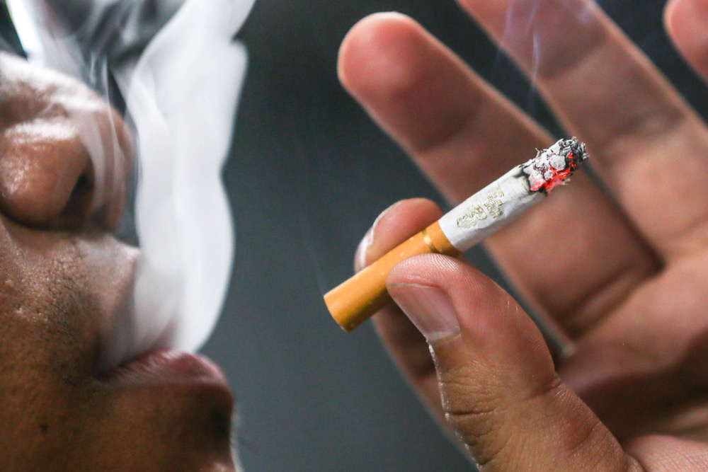 A man smokes a cigarette, January 28, 2022. u00e2u20acu201d Picture by Hari Anggara