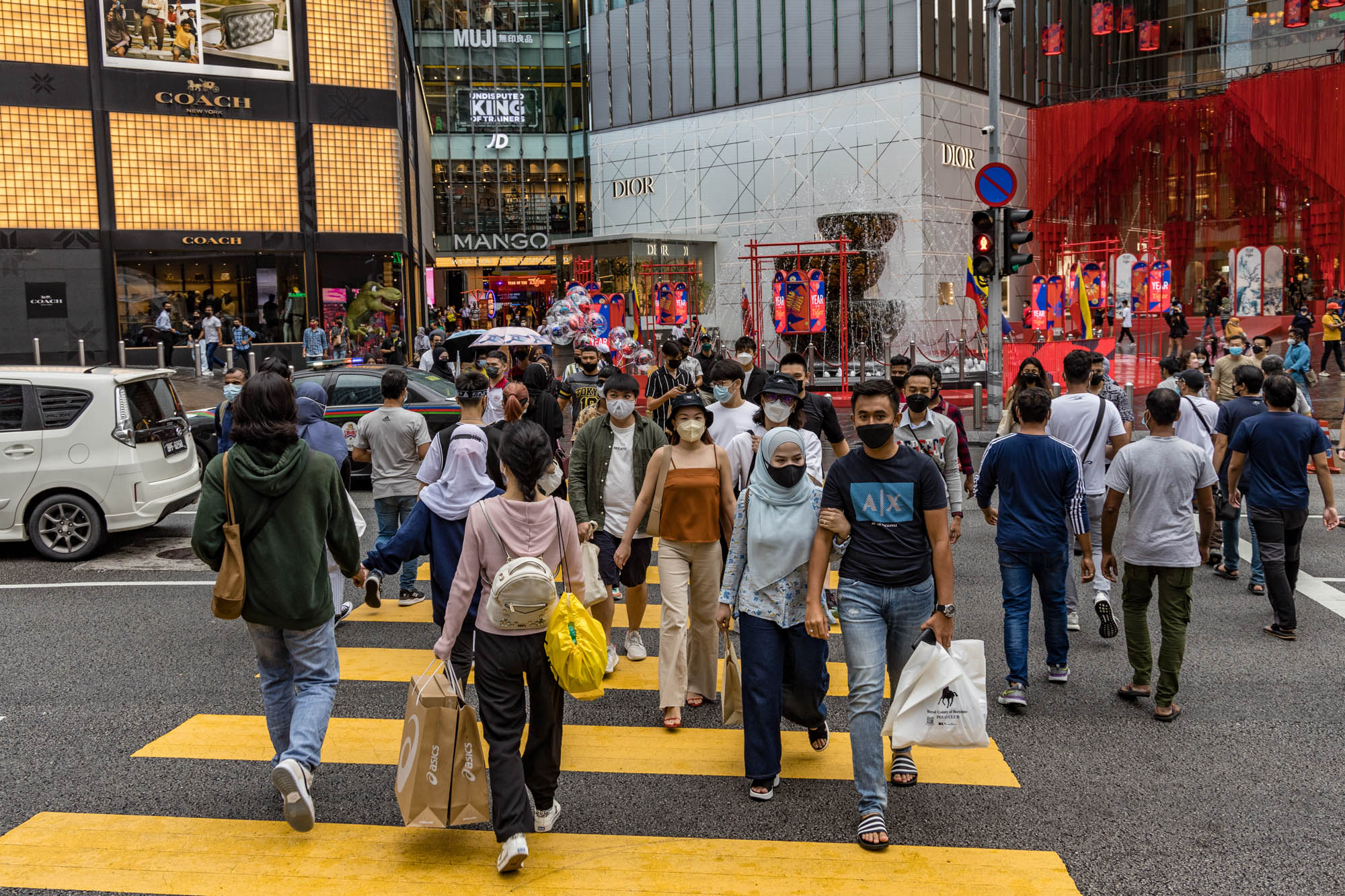 People are seen wearing protective masks as they walk along the Bukit Bintang shopping area in Kuala Lumpur February 13, 2022. — Picture by Firdaus Latif