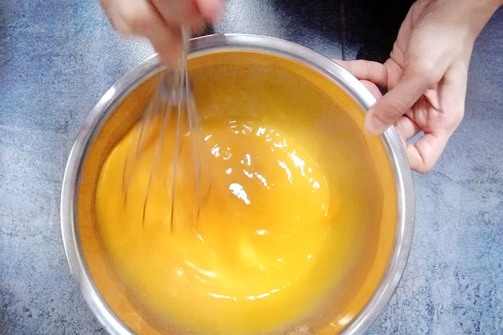 Whisking the eggs to make the custard.