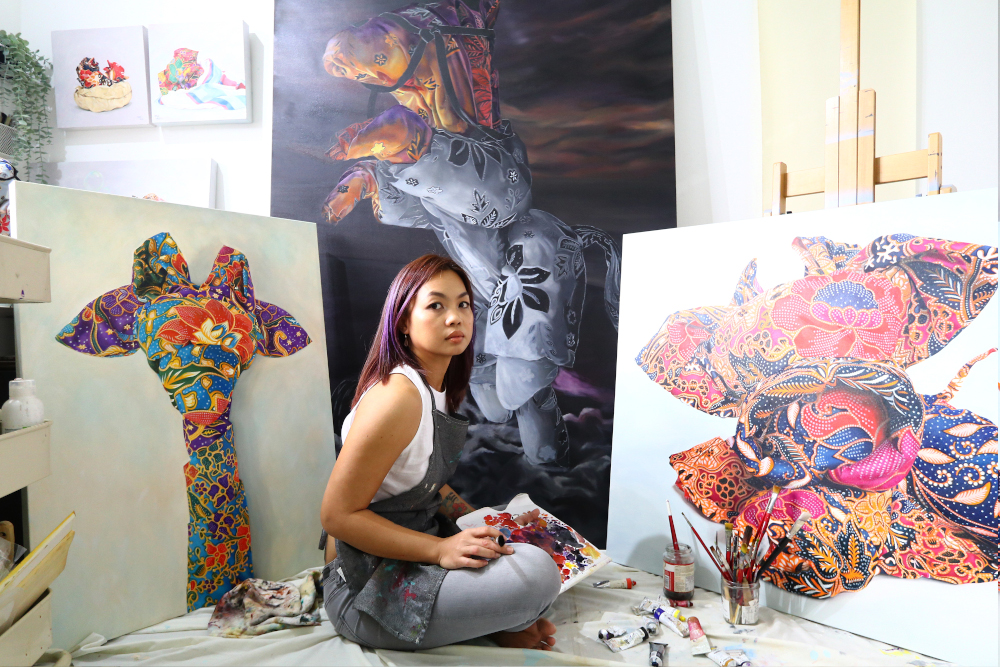 Penang artist Mandy Maung with her oil paintings of Orikata Tales.  — Picture courtesy of Oh Chin Eng