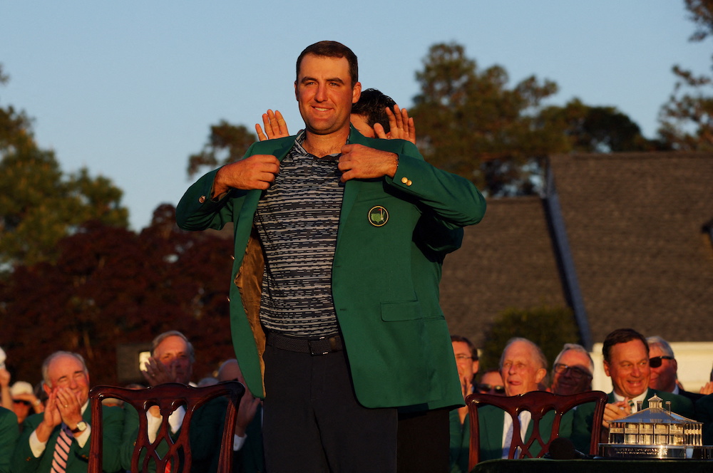 Scottie Scheffler has his green jacket put on by previous winner Japan's Hideki Matsuyama after winning The Masters in Augusta, Georgia April 10, 2022. u00e2u20acu201d Reuters pic