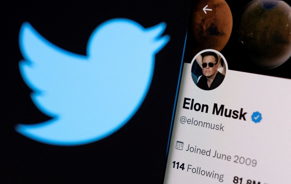 Elon Musku00e2u20acu2122s twitter account is seen on a smartphone in front of the Twitter logo in this photo illustration taken, April 15, 2022. u00e2u20acu201d Reuters pic
