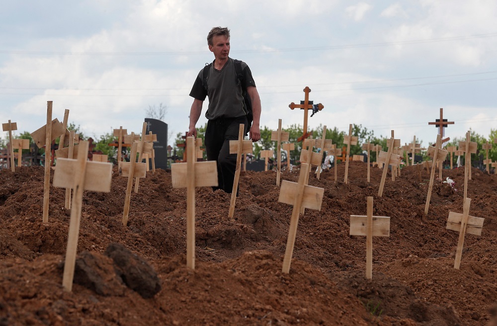 A man walks amid newly-made graves at a cemetery in the course of Ukraine-Russia conflict in the settlement of Staryi Krym outside Mariupol, Ukraine May 15, 2022. u00e2u20acu201d Reuters pic