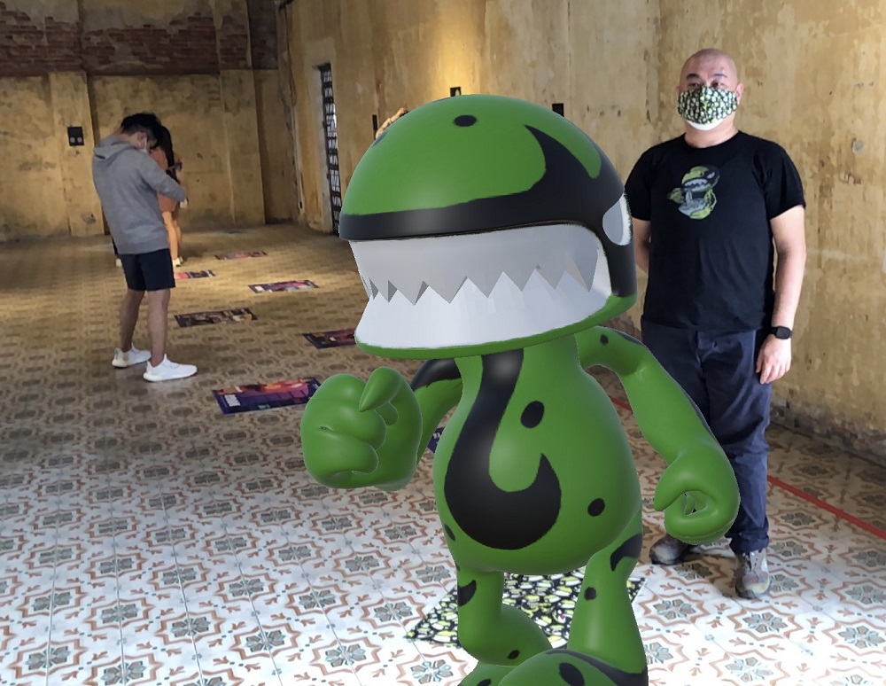 Lim Chun Woei of Urban Cr3atures with his AR green monster at the exhibition. 