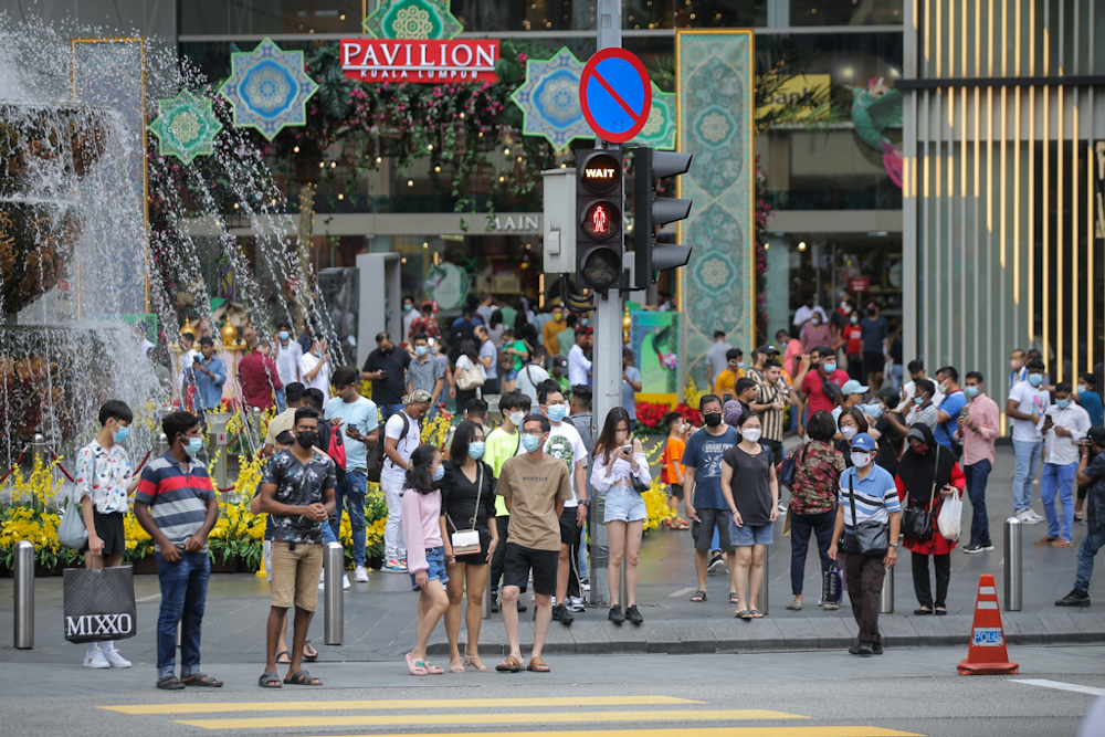 People wearing face masks sightsee and snap pictures in the heart of Kuala Lumpur during Hari Raya Aidilfitri holiday May 3, 2022. — Picture by Ahmad Zamzahuri 