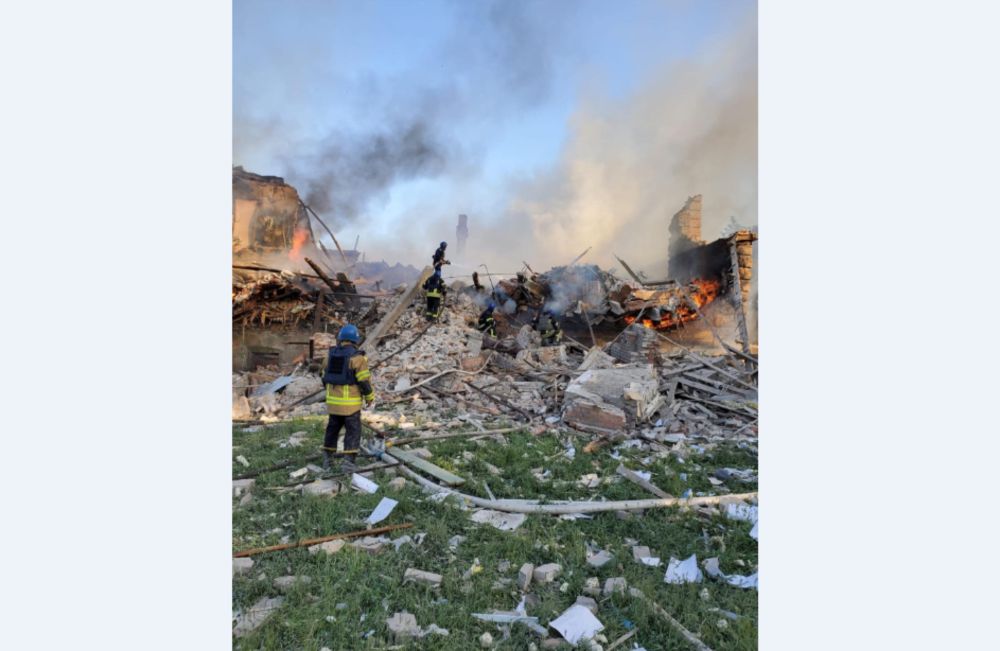 Emergency crew tend to a fire near a burning debris, after a school building was hit as a result of shelling, in the village of Bilohorivka, Luhansk, Ukraine, May 8, 2022. — State Emergency Services/Handout via Reuters