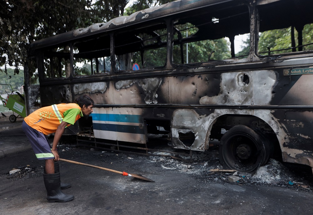 A man looks at a damaged bus of Sri Lanka's ruling party supporters after it was set on fire during a clash of pro and anti-government demonstrators near the prime minister's official residence, amid the country's economic crisis, in Colombo, Sri Lanka May 10, 2022. ― Reuters pic