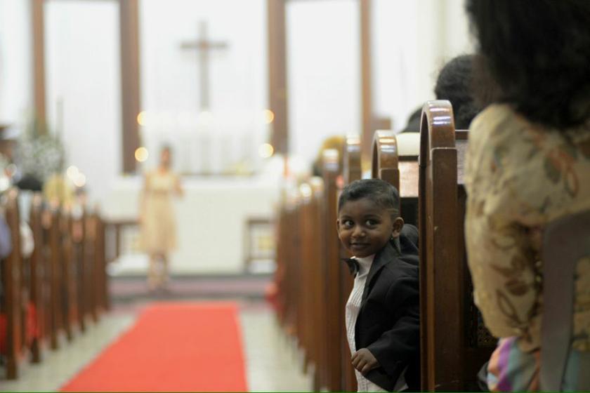 A boy smiling to fellow Christian that attending the Christmas eve midnight mass at the St George's church in Penang, December 25, 2013. u00e2u20acu201d Picture by K.E. Ooi