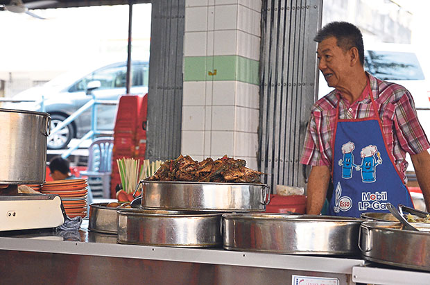 The affable proprietor of the Teochew porridge stall has a smile and greeting for every customer.