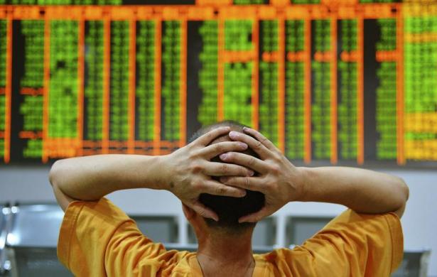 An investor sits in front of an electronic board showing stock information at a brokerage house in Hangzhou, Zhejiang province, June 24, 2013.n